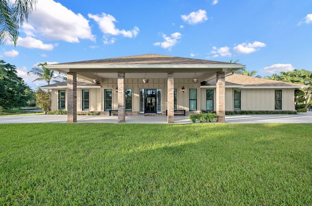 rear view of house with a lawn and covered porch