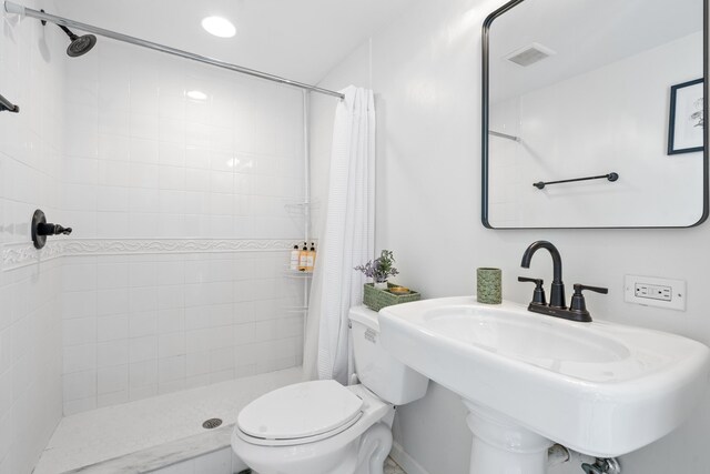 bathroom with a shower with curtain, toilet, and sink