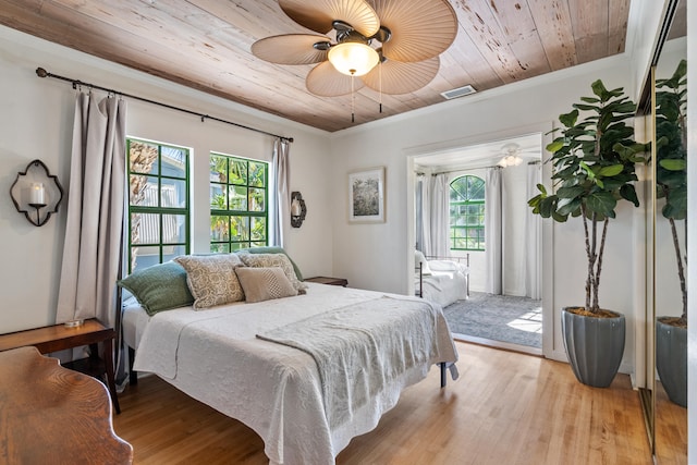 bedroom featuring wooden ceiling, ceiling fan, light wood-type flooring, and multiple windows