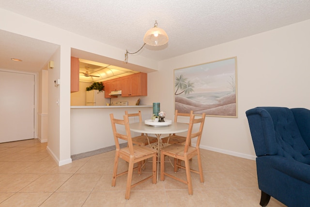 dining room with light tile patterned flooring and a textured ceiling