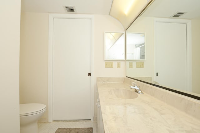 bathroom with tile patterned flooring, vanity, and toilet