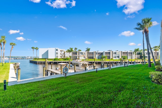 view of dock featuring a lawn and a water view