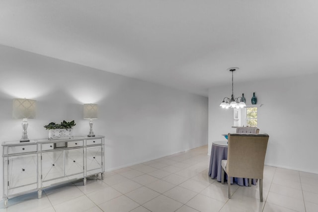 dining space with light tile patterned floors and an inviting chandelier