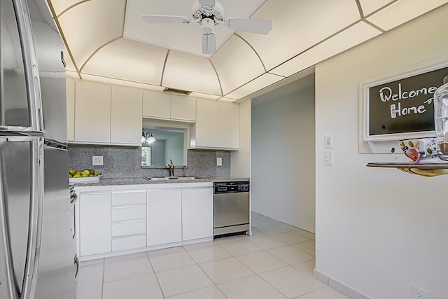 kitchen featuring white cabinetry, sink, decorative backsplash, light tile patterned floors, and appliances with stainless steel finishes