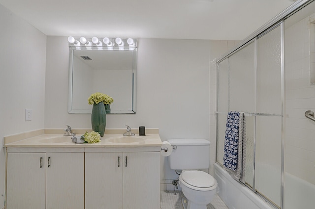 full bathroom featuring tile patterned floors, vanity, enclosed tub / shower combo, and toilet