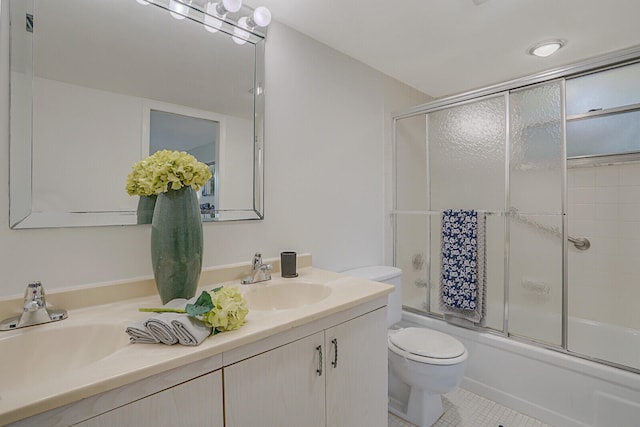 full bathroom featuring combined bath / shower with glass door, vanity, tile patterned floors, and toilet