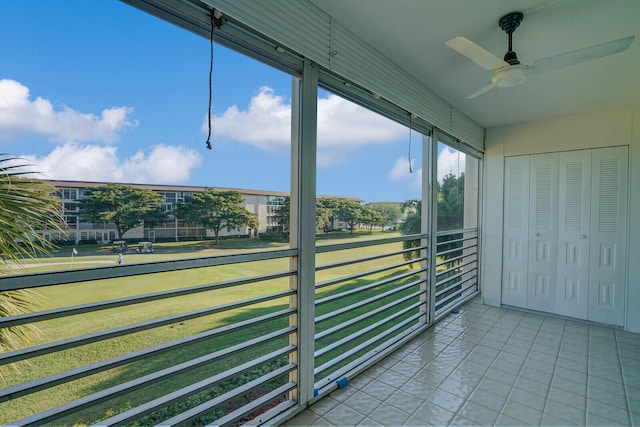 unfurnished sunroom featuring ceiling fan