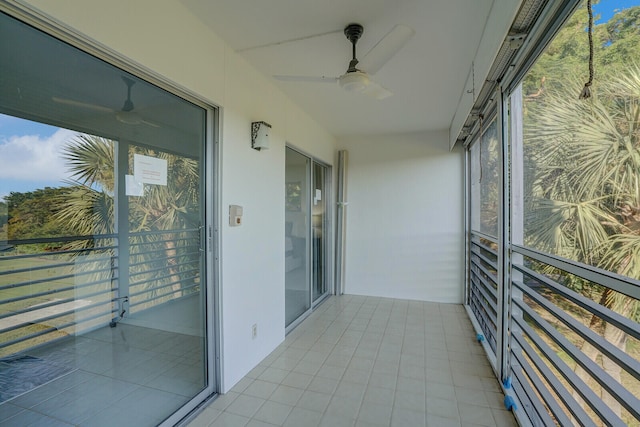 unfurnished sunroom with ceiling fan