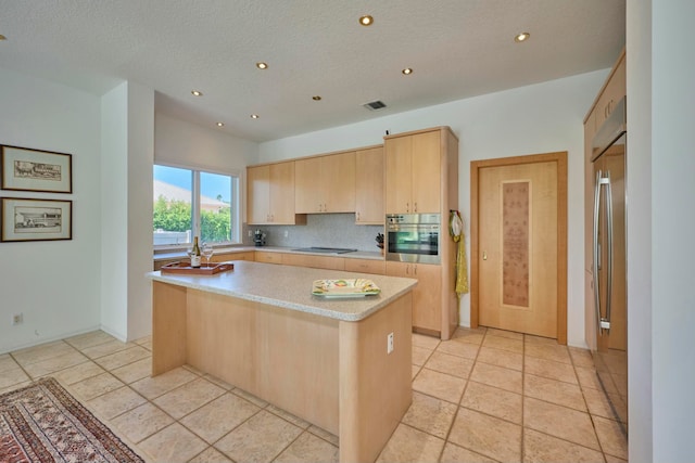 kitchen featuring a textured ceiling, a center island, stainless steel appliances, and light brown cabinets