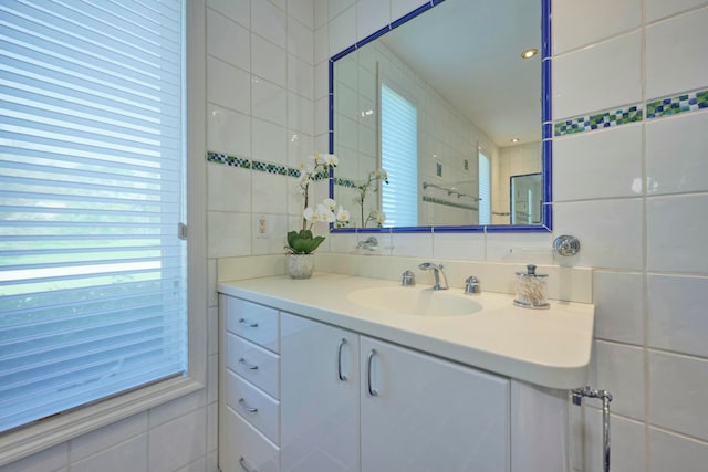 bathroom featuring vanity and tile walls