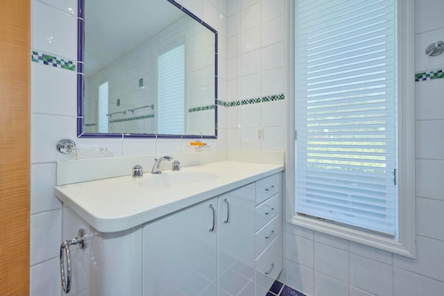 bathroom featuring vanity, decorative backsplash, and tile walls