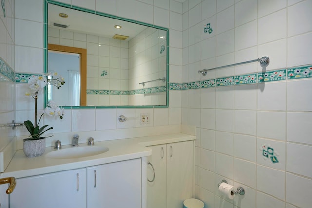 bathroom with backsplash, vanity, and tile walls