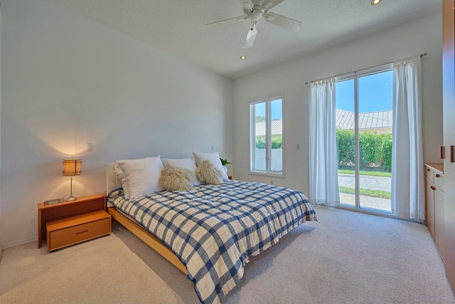 carpeted bedroom with ceiling fan, access to exterior, and a textured ceiling