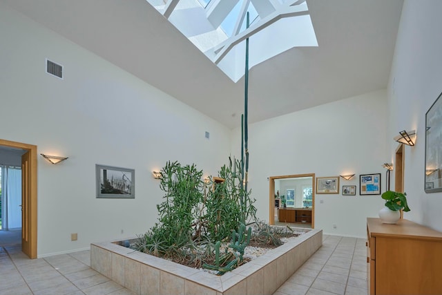 hallway featuring a healthy amount of sunlight, high vaulted ceiling, and a skylight