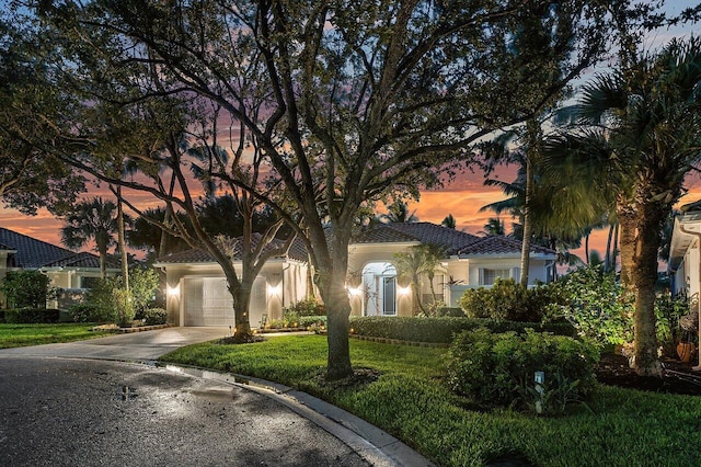 7580 Red River Rd, West Palm Beach, FL 33411 - view of front of home with stucco siding, concrete driveway, a tile roof, a garage, and a yard
