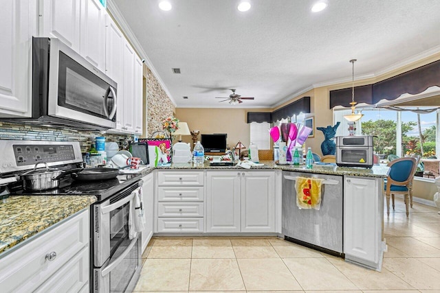 7580 Red River Rd, West Palm Beach, FL 33411 - kitchen featuring appliances with stainless steel finishes, white cabinets, a ceiling fan, decorative backsplash, and a peninsula