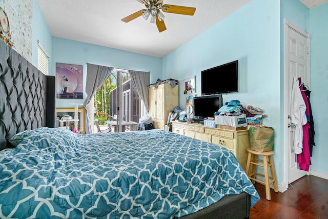 bedroom featuring access to exterior, a textured ceiling, ceiling fan, and dark wood-type flooring