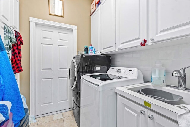 washroom with separate washer and dryer, sink, light tile patterned floors, and cabinets