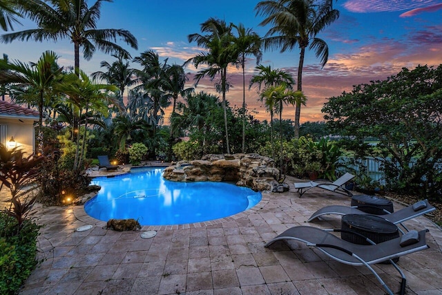 pool at dusk with a patio