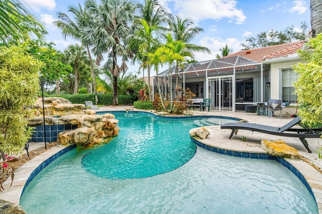 view of swimming pool featuring glass enclosure and a patio area