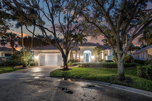 7580 Red River Rd, West Palm Beach, FL 33411 - mediterranean / spanish house with an attached garage, stucco siding, a tile roof, and concrete driveway