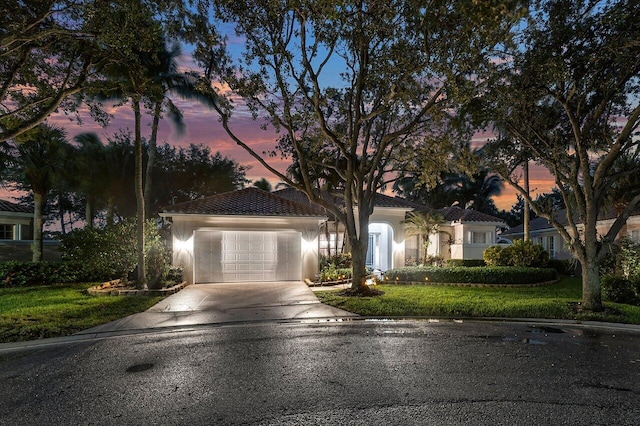 view of front of property with a yard and a garage