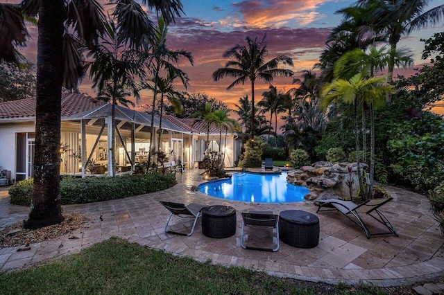 pool at dusk with a patio