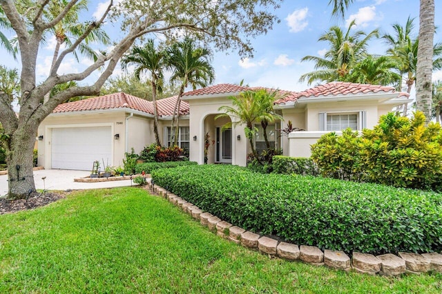 7580 Red River Rd, West Palm Beach, FL 33411 - mediterranean / spanish-style house featuring stucco siding, a tile roof, an attached garage, driveway, and a front lawn