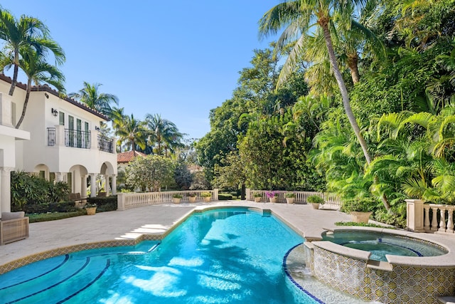 view of swimming pool featuring a patio area and an in ground hot tub