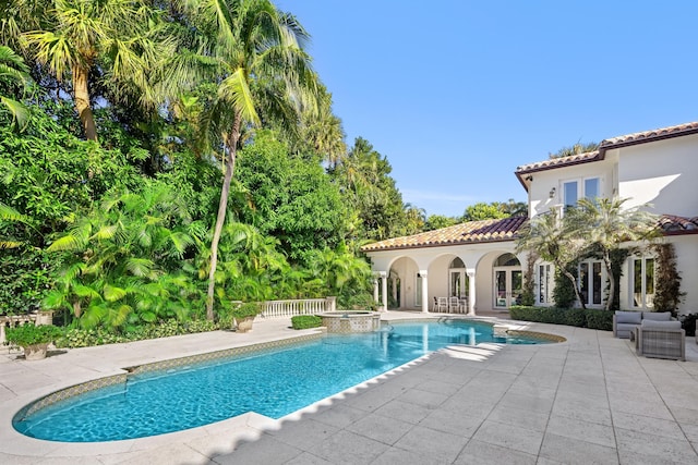 view of pool featuring an in ground hot tub and a patio