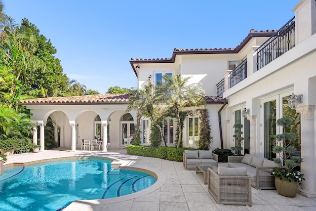 back of house featuring a balcony, an outdoor hangout area, and a patio