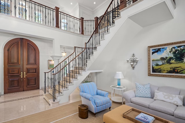 living room featuring a towering ceiling and ornamental molding