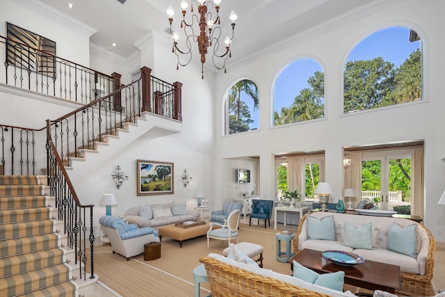 living room featuring a towering ceiling, an inviting chandelier, french doors, and crown molding