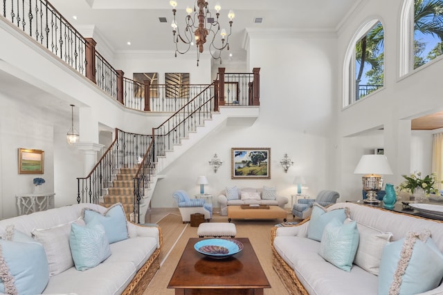 living room with a high ceiling, an inviting chandelier, and ornamental molding