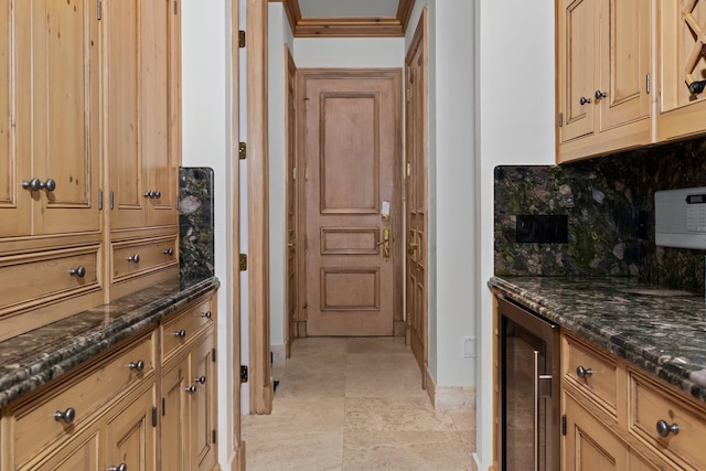 kitchen featuring dark stone counters, ornamental molding, backsplash, and wine cooler