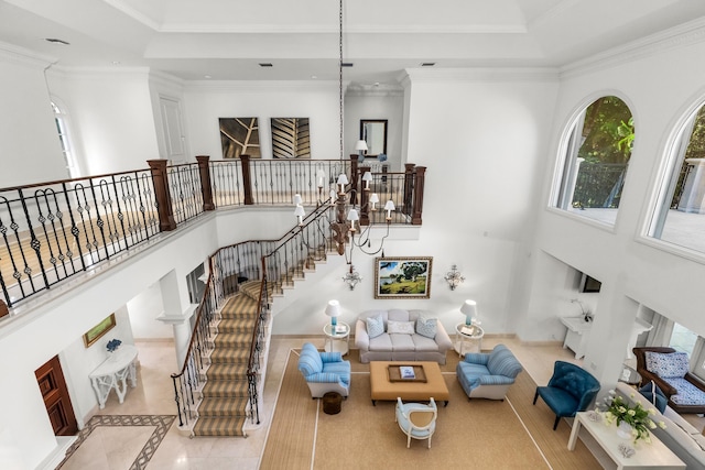 living room featuring a towering ceiling, light tile patterned floors, and crown molding