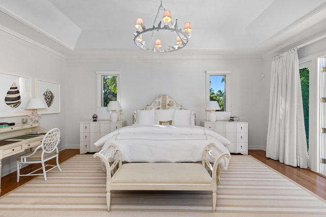 bedroom featuring multiple windows, an inviting chandelier, light wood-type flooring, and crown molding