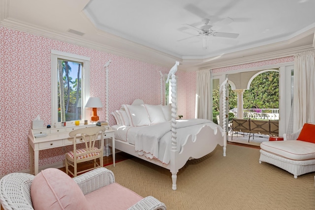 carpeted bedroom featuring a raised ceiling, ceiling fan, and ornamental molding