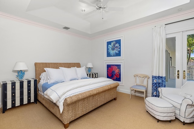 carpeted bedroom with ornamental molding, french doors, ceiling fan, and a tray ceiling