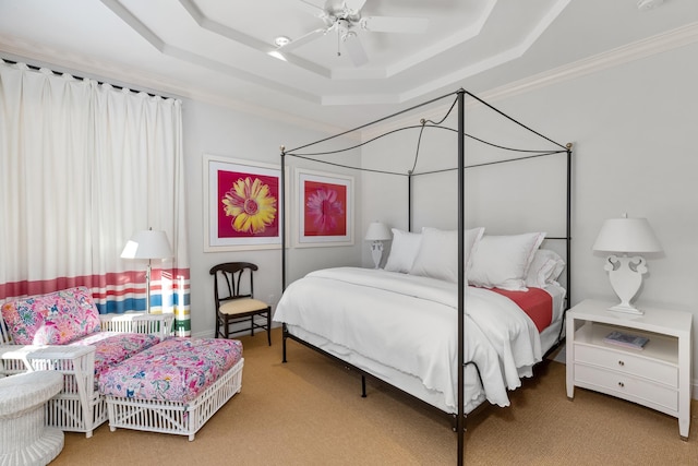 bedroom with ornamental molding, a raised ceiling, ceiling fan, and carpet flooring