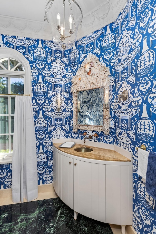 bathroom with vanity, a notable chandelier, and crown molding