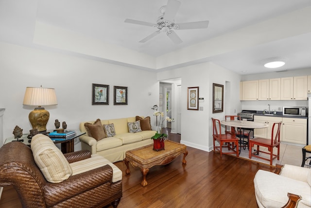 living room featuring ceiling fan and dark wood-type flooring