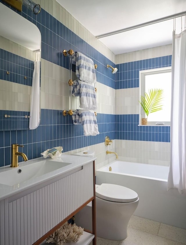 full bathroom featuring vanity, toilet, shower / bathtub combination with curtain, and tile walls