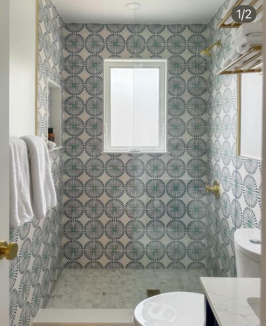 bathroom featuring plenty of natural light and tile walls