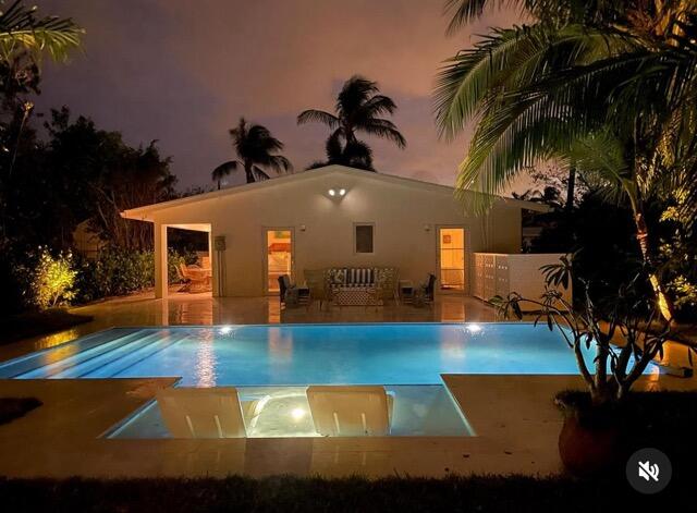 pool at twilight featuring a patio