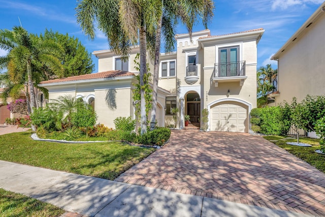 mediterranean / spanish home with a balcony and a front yard