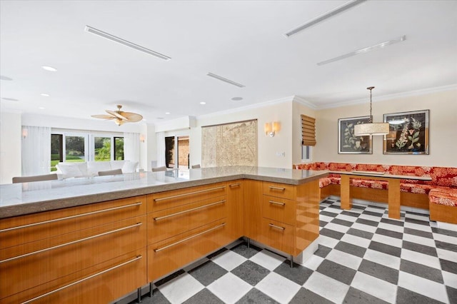 kitchen with kitchen peninsula, ceiling fan, decorative light fixtures, and ornamental molding