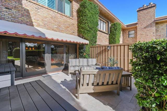 wooden deck with outdoor lounge area, a patio, and french doors