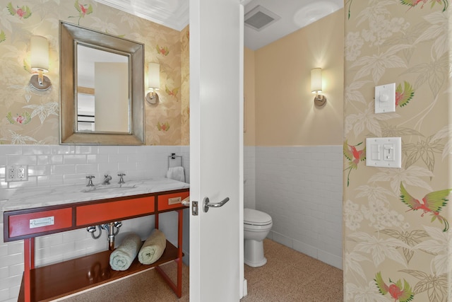 bathroom with vanity, toilet, tile walls, and crown molding