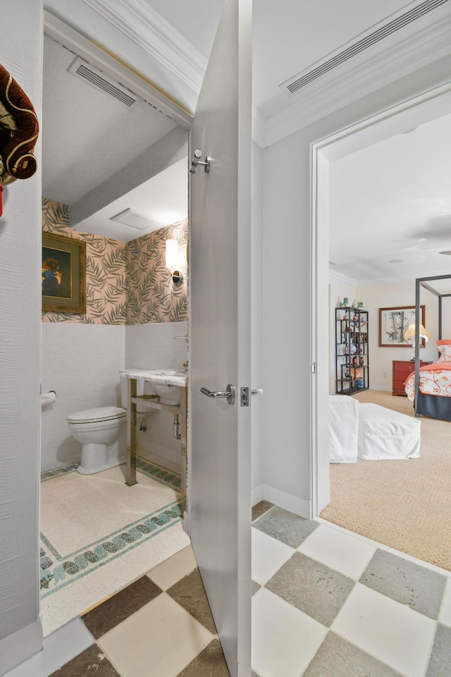 bathroom featuring toilet and crown molding